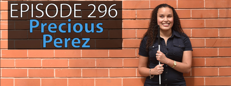 Precious Perez, a young woman with curly shoulder length dark hair and holding a mobility cane, smiles and poses for the camera. The words “AT Banter Episode 296 – hover over the top left hand side of the image.