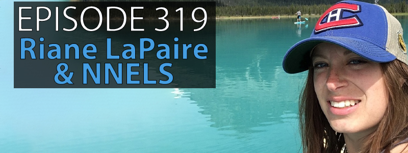Riane LaPaire, woman in her 30s with long brown hair and wearing a Montreal Canadians baseball hat, smiles in front of a blue green lake. The words "Episode 319 - Riane Lapaire & NNELS" takes up the left hand side of the image.