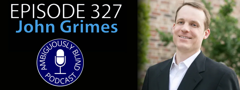 John Grimes, a Caucasian man with short brown hair and dressed in a suit smiles for the camera. The words "Episode 327 - John Grimes" hovers over the left hand side of the photo.